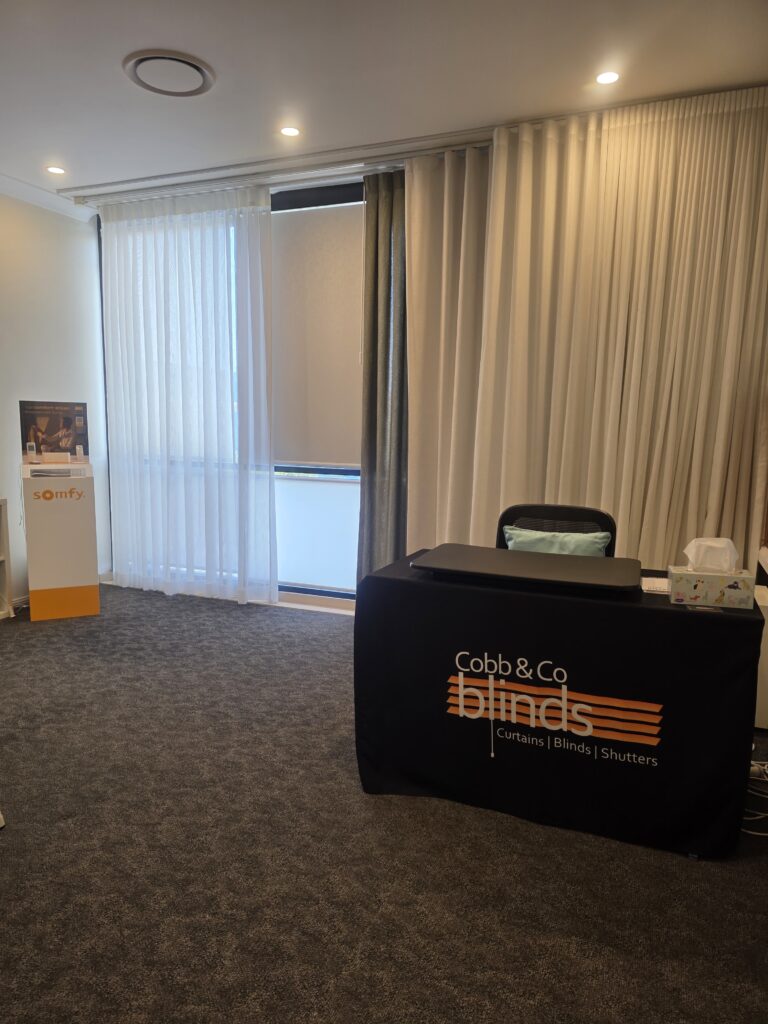 Sheer and blockout curtains on display beside the Cobb & Co Blinds welcome desk