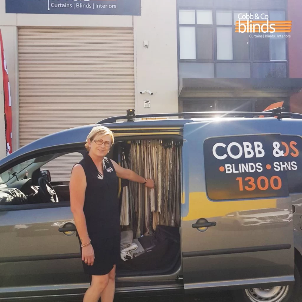 cobb and co blinds van with a woman showing the blinds inside the van