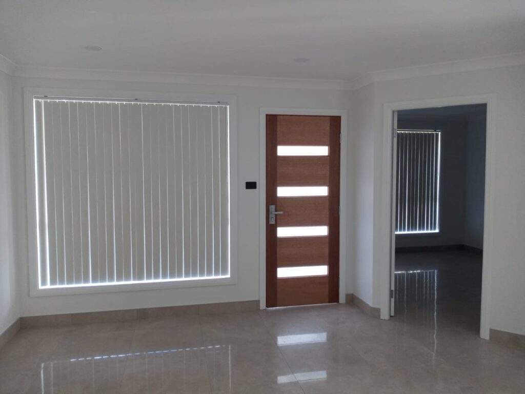 White PVC vertical blinds on a large entry window