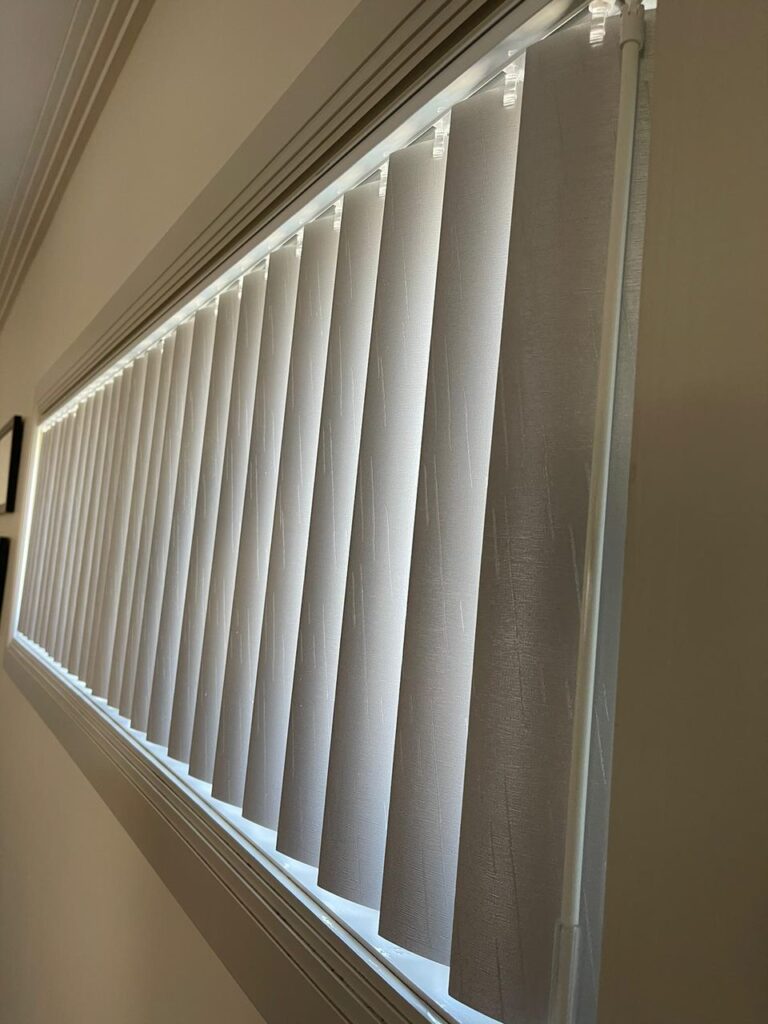 Textured PVC vertical blind slats on a long window