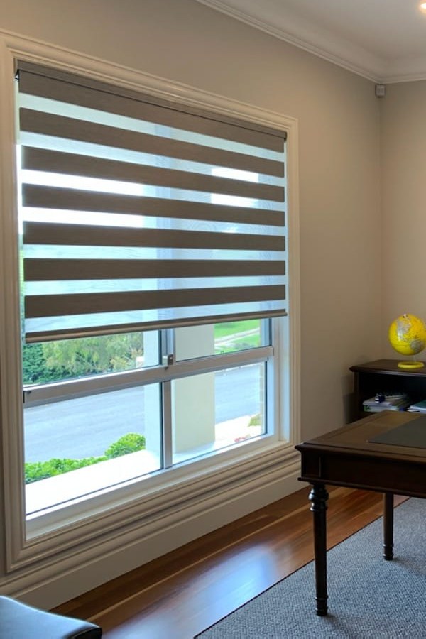 Zebra blind partly raised on a home office window